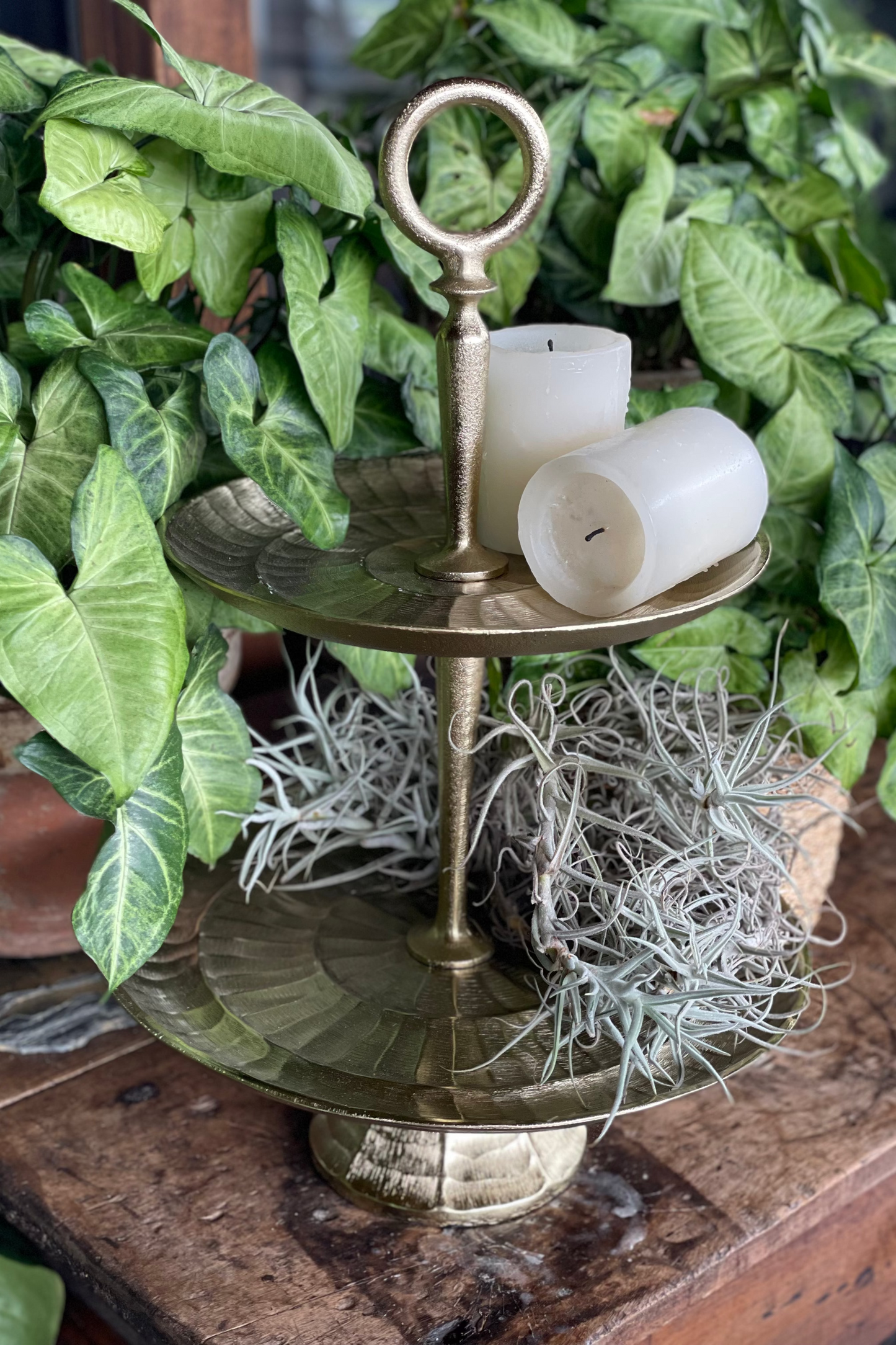 Centro de mesa de dos niveles en metal con acabado dorado envejecido para servir postres, frutas y decorar el hogar.