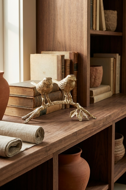 Figura decorativa de dos pájaros sobre una rama en metal dorado envejecido para bibliotecas, consolas y mesas.
