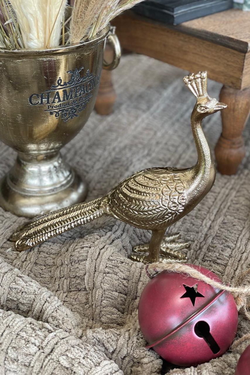 Pava real decorativa en metal con acabado dorado envejecido para mesas, consolas y estanterías.