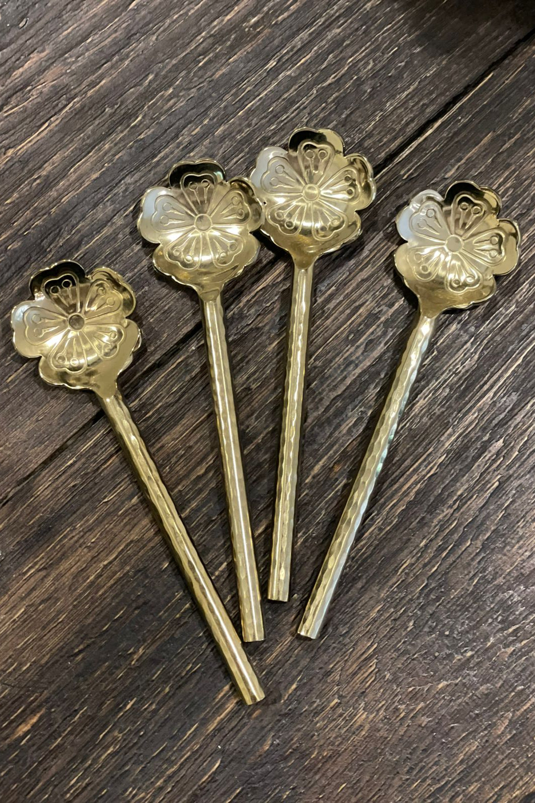 Set de cuatro cucharitas de metal con diseño de flor y acabado dorado para café, té y postres.