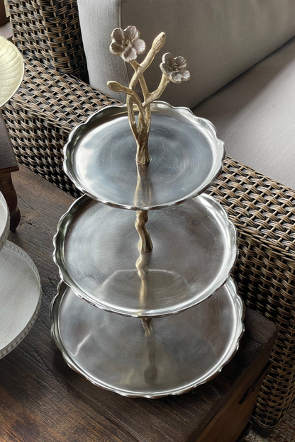 Torre decorativa floral de tres niveles en metal plateado envejecido para servir postres, frutas o decorar mesas y consolas.